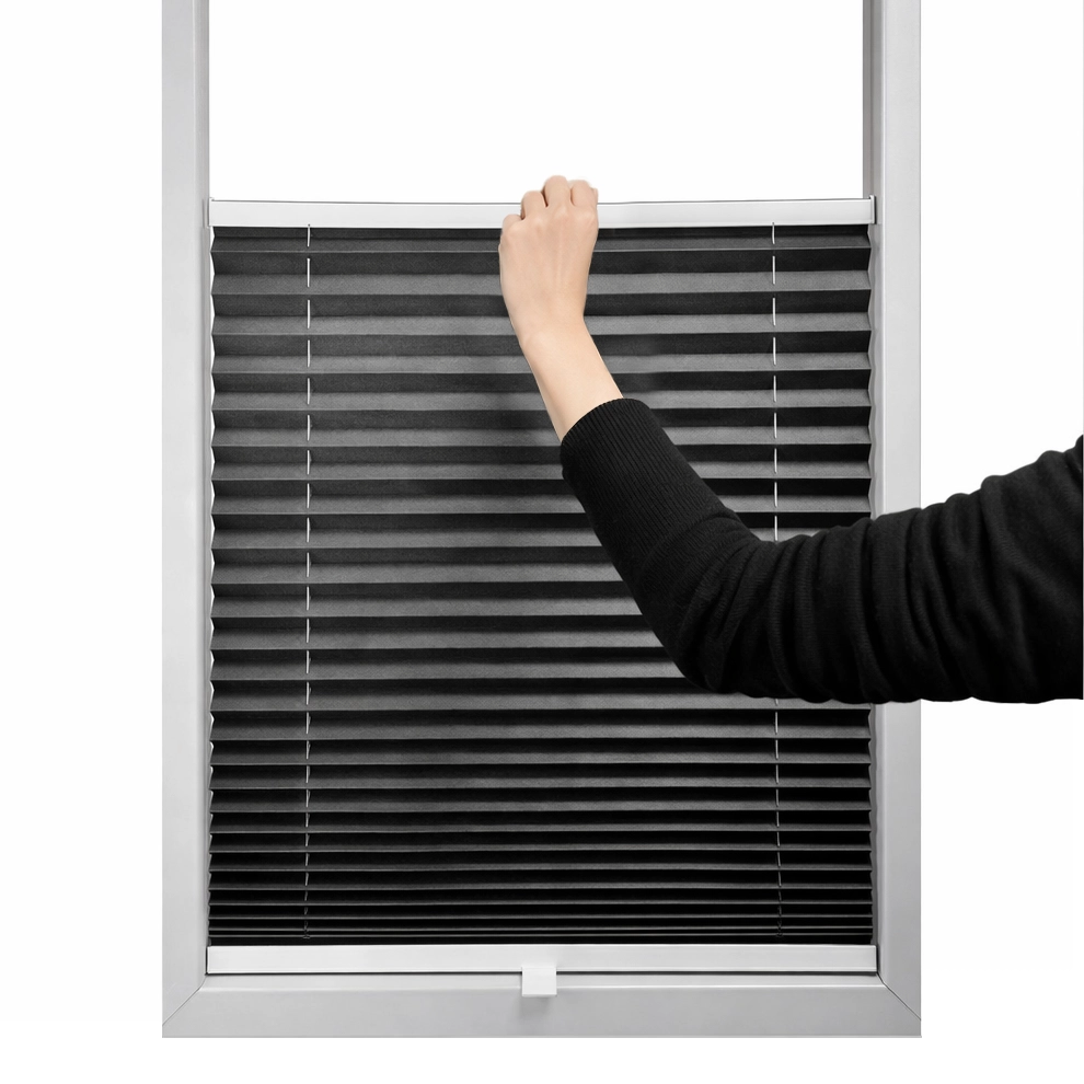 Kéz alulról felfelé mozgatja a pliszé rolót a fény és a magánszféra szabályozásához.