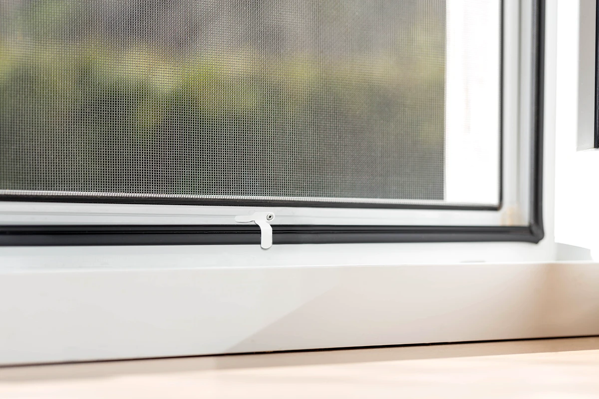 Az ablakkeretbe szerelt szúnyogháló részlete az alsó rögzítéssel.